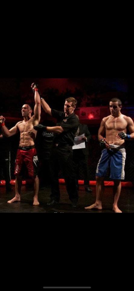 Victory declared — Full Circle fighter hand raised in the cage.